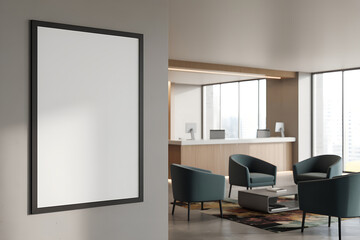 Fototapeta premium Blank framed poster hanging on a wall in a modern hotel lobby waiting area