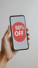 Hand holding smartphone displaying 50% off sale offer  
