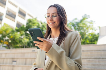 Businesswoman smiling while checking her smartphone