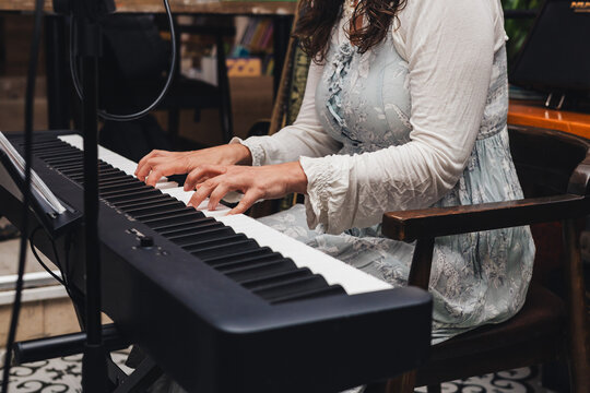 Woman playing keyboard at live music event - Powered by Adobe