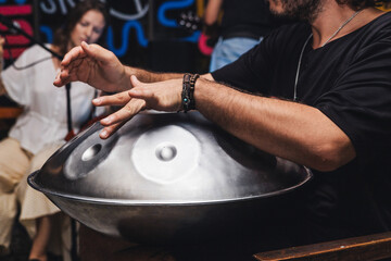 Man playing a handpan at a live music concert
