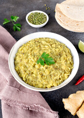 Indian Khichari with rice,lentils served with roti on gray background. Top view. Ayurveda diet