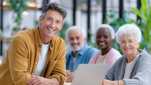Young volunteer helping seniors with online learning in bright cafe  