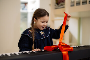 Excited Girl Untying Ribbon on Piano