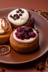 Cinnamon roll, a sweet bun with citrus, cherries, and chocolate, a Danish dessert with cream