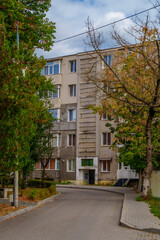 Soviet-style apartment building behind autumn trees