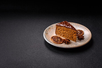 A slice of sweet layered cake covered in chocolate with nuts and caramel. A slice of chocolate cake