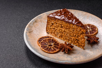 A slice of sweet layered cake covered in chocolate with nuts and caramel. A slice of chocolate cake