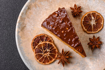 A slice of sweet layered cake covered in chocolate with nuts and caramel. A slice of chocolate cake