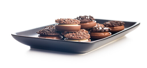 Sweet chocolate pralines. Chocolate candies on plate isolated on white background.