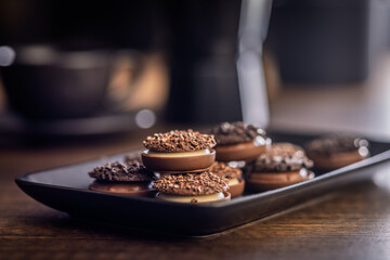 Sweet chocolate pralines. Chocolate candies on plate on wooden table.