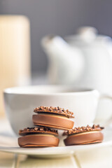 Sweet chocolate pralines. Chocolate candies and coffee cup on white table.