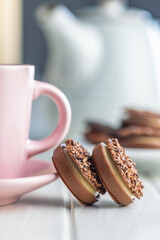 Sweet chocolate pralines. Chocolate candies and coffee cup on white table.