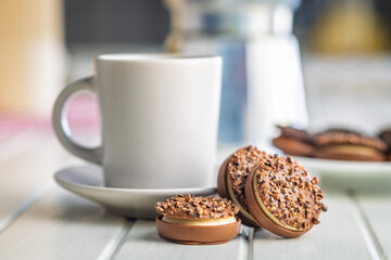 Sweet chocolate pralines. Chocolate candies and coffee cup on white table.