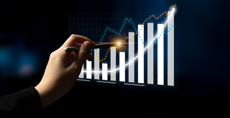 A hand points at a financial chart showing an upward trend. The image represents business growth,...