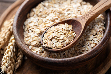 Dry Rolled oats in wooden bowl, healthy dietary fiber