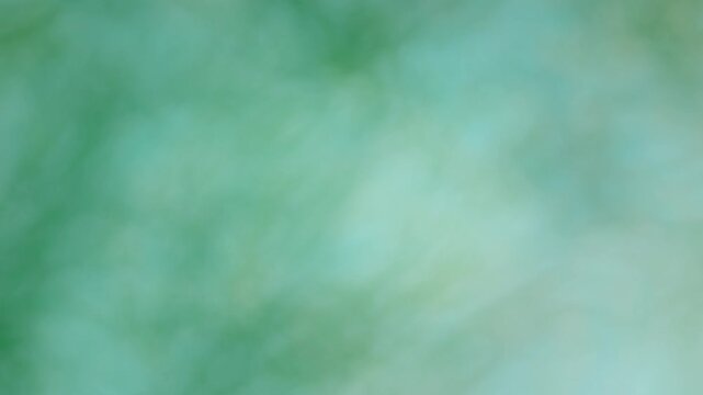 green emerald aquatic haze marble tie dye effect animated motion background with veins of colour running through expanding clouds of of overlapping colours in soft warm pastel tones 4k animation