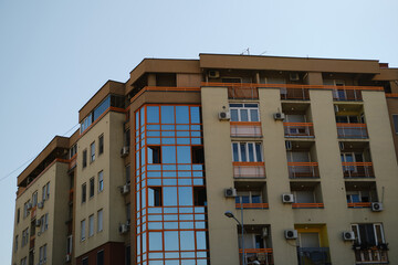 Apartment building with orange balconies and glass facade elements in Novi Sad, Serbia.