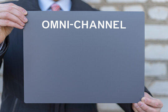 Business person holding template gray banner sees the inscription OMNI-CHANNEL. Omnichannel Business Marketing Customer Concept. Omni Channel Database Service Information Technology.