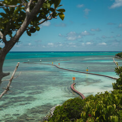 Scenic View of Turquoise Waters and a Wooden Path Extending into the Ocean Under a Partly Cloudy Sky