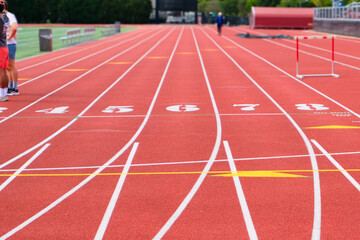 Red running track with numbered lanes and hurdles, ready for training or competition, capturing the energy and focus of athletics.