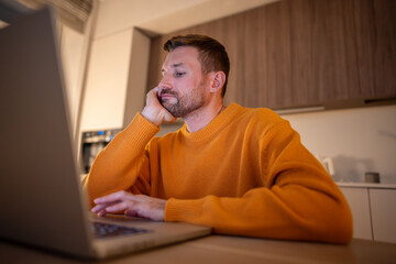 Man tired working on laptop, feeling exhaustion and boredom. Male meet deadlines, focus slip, long hours drain energy, persistent effort, mental strain, dedication despite overwhelming fatigue