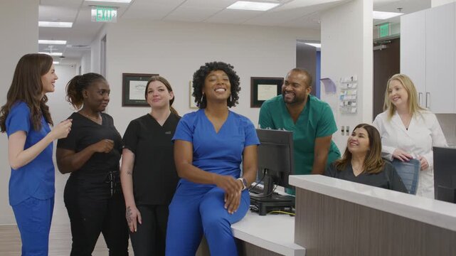Group portrait of a healthcare team at a nurse station in a clinical office setting.