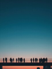 Silhouettes of people gather on a bridge during sunset, creating a serene scene against a fading blue sky transitioning to warm hues.