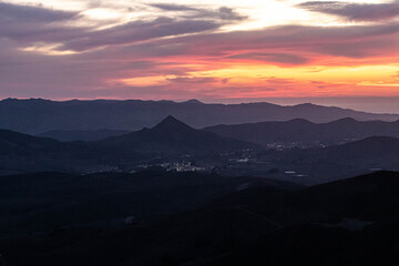 sunset over the mountains with vibrant clouds