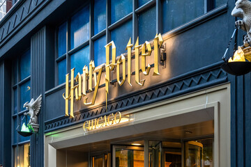 Fototapeta premium Chicago, Illinois, USA. Oct 2, 2025. Close-up of a Harry Potter Store entrance featuring a large, ornate golden sign above a doorway, flanked by bird-like sculptures with glowing bowls.