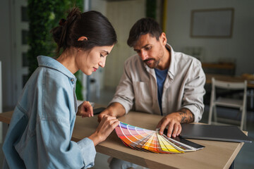 Happy couple choosing color swatches for home renovation
