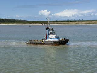 Obraz premium tug boat working in port for mooring cargo ship 1