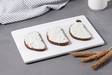 Sandwiches with cream cheese on a white cutting board
