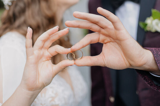 Close-up of bride and groom hands with gold wedding rings, showing love, marriage, and lifelong commitment