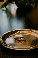 Gold wedding rings in jewelry box, close-up of elegant rings for bride and groom, symbol of love and commitment