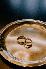 Gold wedding rings in jewelry box, close-up of elegant rings for bride and groom, symbol of love and commitment