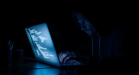 Hacker Working on a Laptop in Dark Room