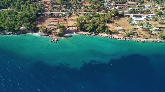 Drone footage captures the aerial perspective of the ancient city of Knidos, nestled along the stunning Aegean coastline of Turkey. This historical site, with its well-preserved ruins and dramatic coa