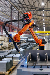 Industrial robot is welding metal part