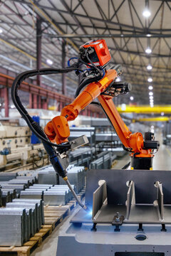 Industrial robot is welding metal part