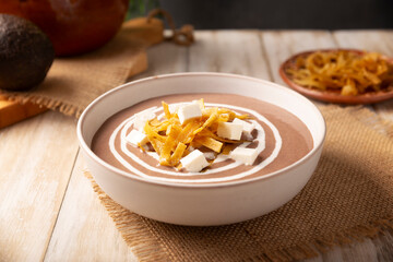 Creamy bean soup. In Mexico known as Crema de Frijoles, nutritious homemade food recipe, commonly accompanied with cheese, cream, avocado and corn tortilla cut into strips and fried.