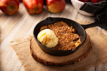 Apple oat crumble, walnuts, butter and brown sugar with vanilla ice cream topping, homemade recipe, traditional dessert perfect for the winter season made in a cast iron skillet.