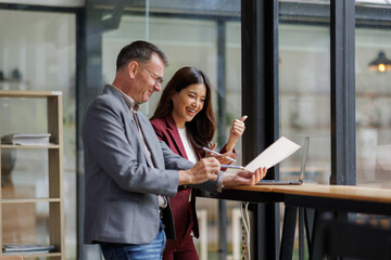 Two business working together using digital tablet pc and talking about a business project. Small creative diversity team of females executives meeting work in office.
