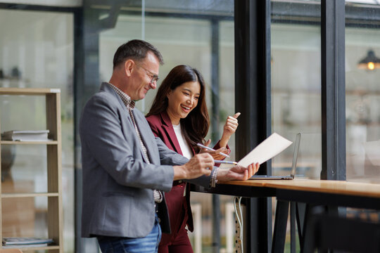 Two business working together using digital tablet pc and talking about a business project. Small creative diversity team of females executives meeting work in office.

