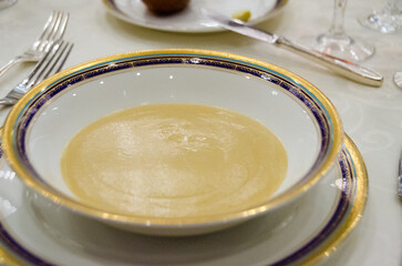 Creamy gourmet soup served in luxury porcelain bowl