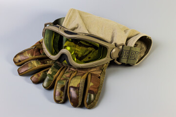 Tactical gear for combat: military goggles and camouflage gloves. Essential protection....