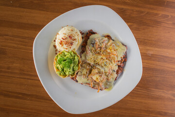 Grilled Steak Topped with Melted Cheese, served with Mashed Potatoes and Guacamole