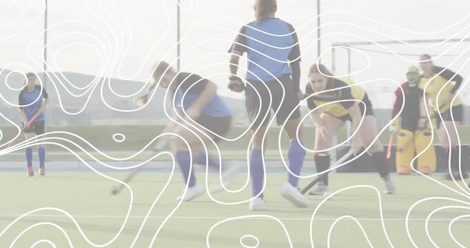 field hockey attacker dribbling past defender, executing low shot and sparking scramble at goal