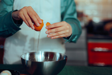 Home Cook Cracking an Egg in a Bowl Making Breakfast. Person separates the egg white from the yolk