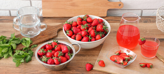Bowl with tasty strawberries and juice on counter in kitchen